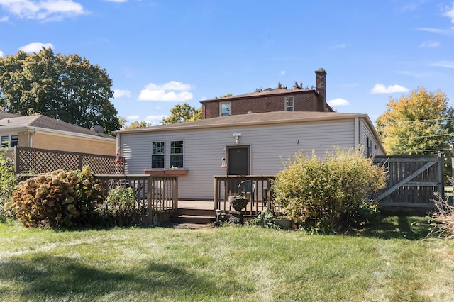 rear view of property with a yard and a wooden deck