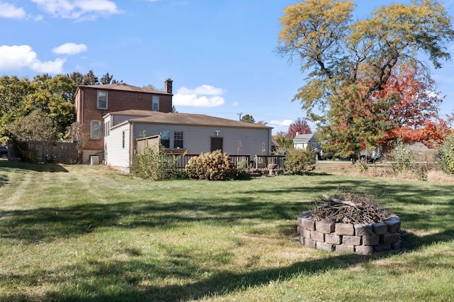 view of yard with a deck and an outdoor fire pit