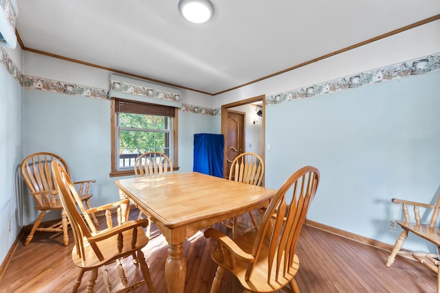 dining space featuring crown molding and wood-type flooring