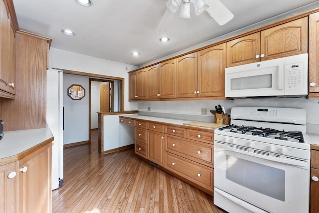 kitchen featuring ceiling fan, light wood-type flooring, and white appliances