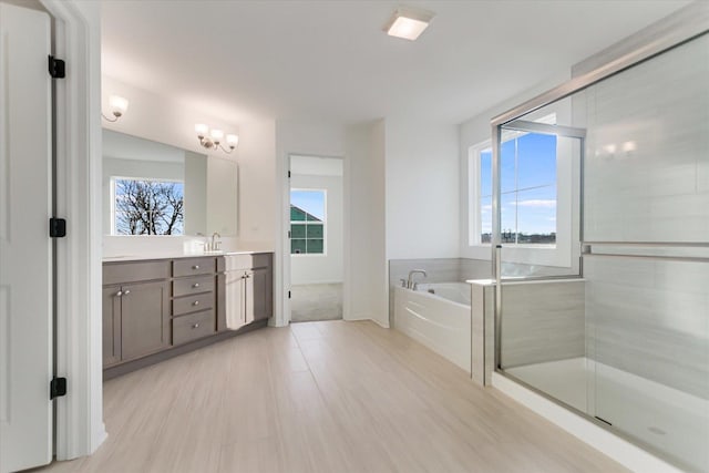 bathroom featuring shower with separate bathtub and vanity