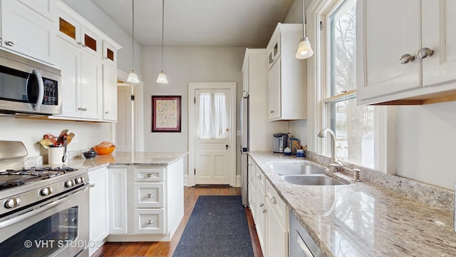 kitchen featuring sink, pendant lighting, white cabinets, and stainless steel appliances