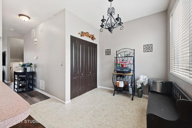 tiled foyer featuring a chandelier