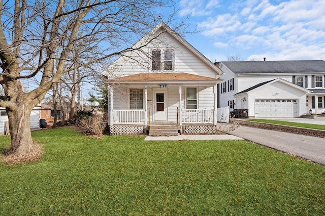 view of front of home with covered porch, a garage, an outdoor structure, and a front yard