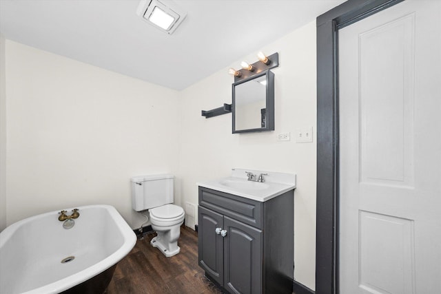 bathroom with hardwood / wood-style flooring, vanity, toilet, and a bath