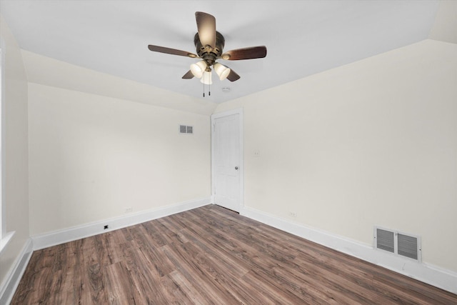 spare room with dark hardwood / wood-style floors, vaulted ceiling, and ceiling fan