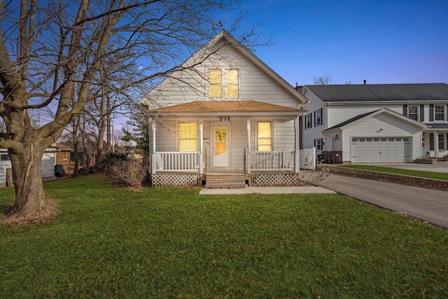 view of front of house with an outdoor structure, a yard, a porch, and a garage