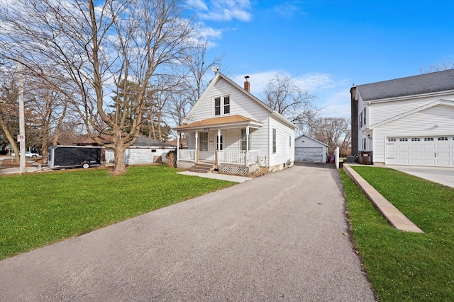 view of front facade featuring a porch, an outbuilding, and a front lawn