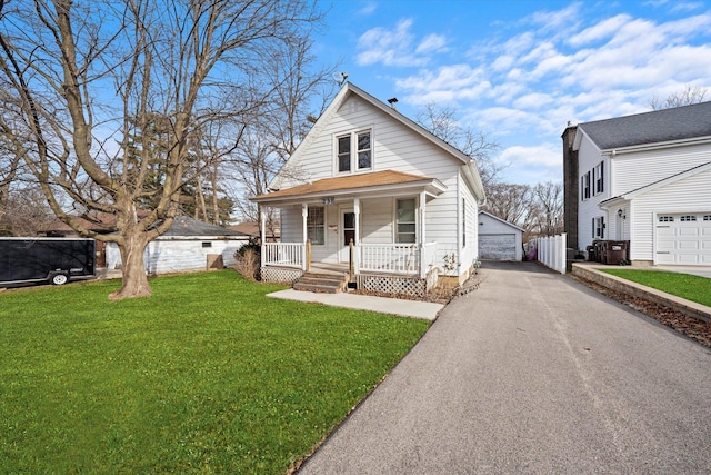 view of front of house with a porch, a garage, an outdoor structure, and a front yard