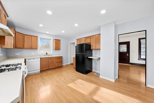 kitchen with white appliances, light hardwood / wood-style floors, and sink