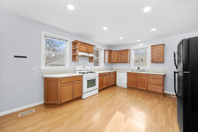 kitchen with white appliances, sink, and light hardwood / wood-style flooring