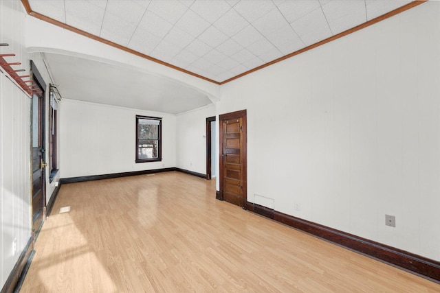 empty room featuring crown molding and light hardwood / wood-style flooring