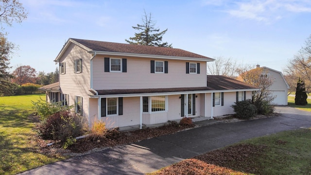 view of front of house featuring a porch, a garage, and an outbuilding