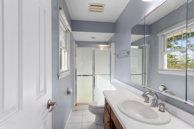 bathroom featuring tile patterned floors, vanity, an enclosed shower, and toilet