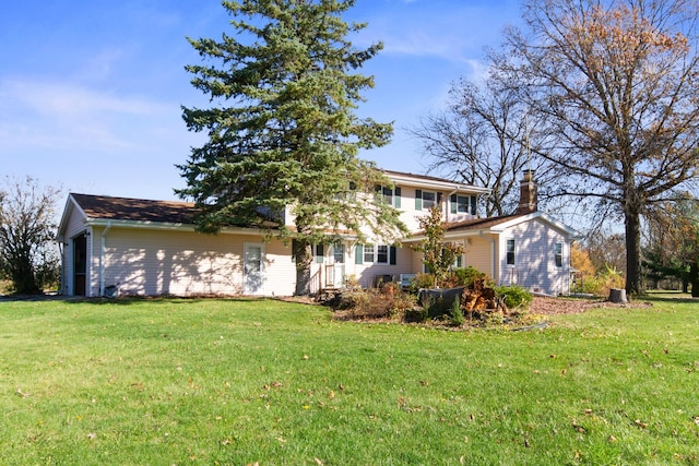 rear view of house featuring a yard and a garage