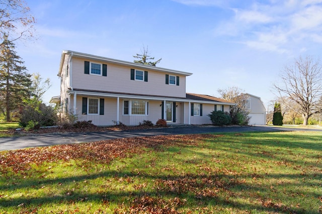 view of front of house with an outbuilding, a front lawn, and a garage