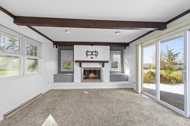 unfurnished living room featuring beam ceiling, carpet, a baseboard radiator, and a brick fireplace