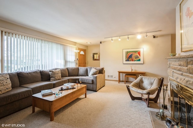 living room with light carpet and a stone fireplace