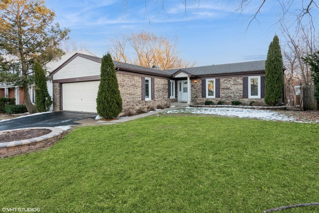 ranch-style home featuring a garage and a front yard