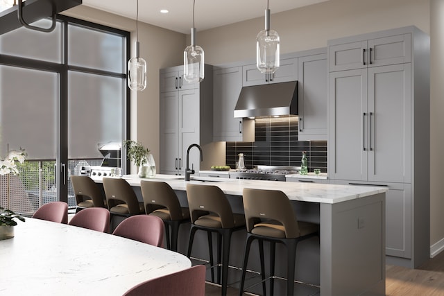 kitchen with light stone counters, range hood, tasteful backsplash, dark hardwood / wood-style flooring, and sink