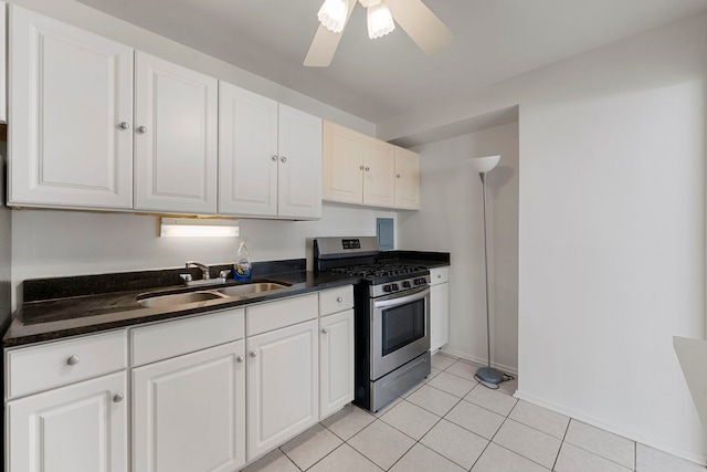 kitchen with gas range, ceiling fan, sink, light tile patterned floors, and white cabinets