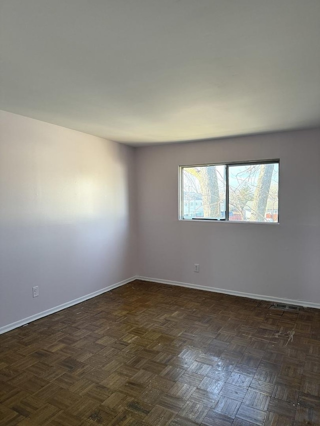 spare room featuring dark parquet floors