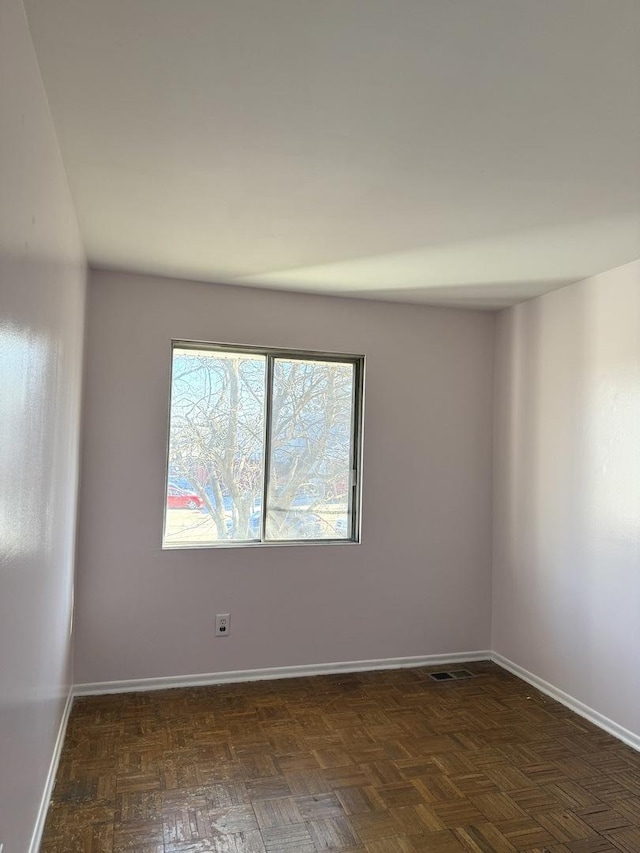 unfurnished room with dark parquet floors