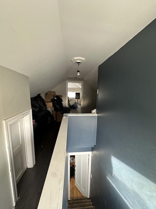 stairway with hardwood / wood-style flooring and lofted ceiling