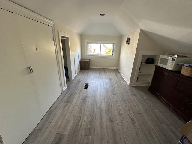 bonus room featuring lofted ceiling and hardwood / wood-style floors