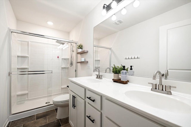 bathroom featuring vanity, toilet, and a shower with shower door