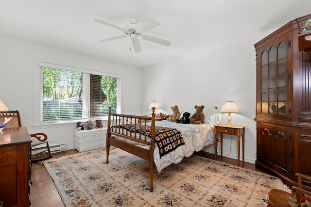 bedroom with ceiling fan, a baseboard radiator, and light hardwood / wood-style flooring