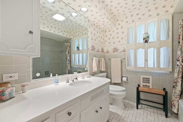 bathroom featuring tile patterned flooring, vanity, toilet, and tile walls