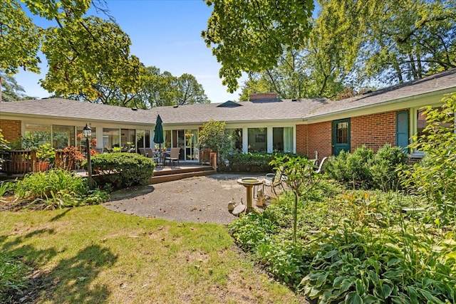 rear view of house featuring a patio area and a yard