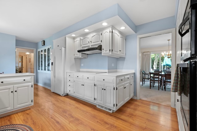 kitchen featuring electric stovetop, white refrigerator with ice dispenser, a notable chandelier, light hardwood / wood-style floors, and white cabinetry