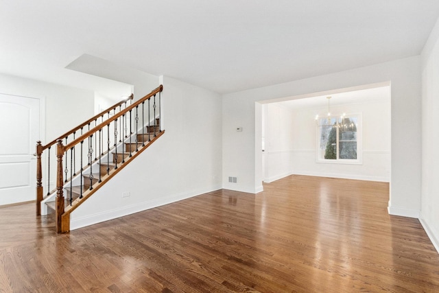 unfurnished living room with a chandelier and hardwood / wood-style flooring