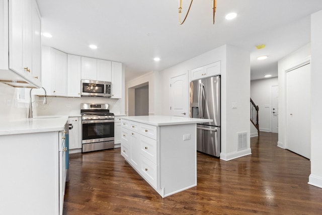 kitchen with white cabinets, a center island, sink, and stainless steel appliances