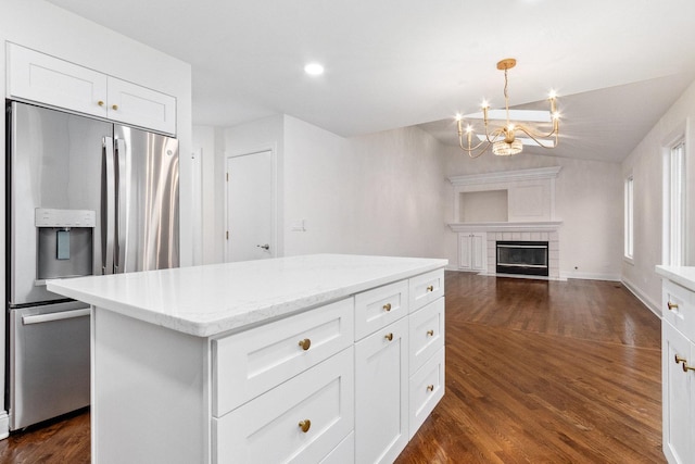 kitchen with stainless steel refrigerator with ice dispenser, a tile fireplace, pendant lighting, dark hardwood / wood-style floors, and white cabinetry