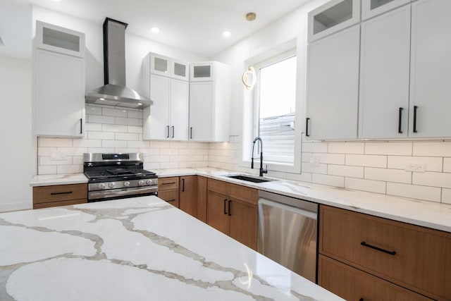 kitchen featuring wall chimney exhaust hood, sink, white cabinetry, and stainless steel appliances