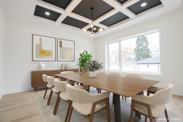 dining space featuring beam ceiling, light hardwood / wood-style floors, and coffered ceiling