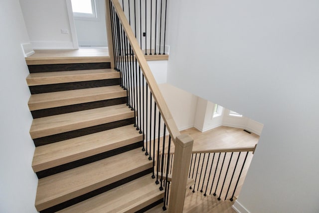 stairs with hardwood / wood-style flooring and plenty of natural light