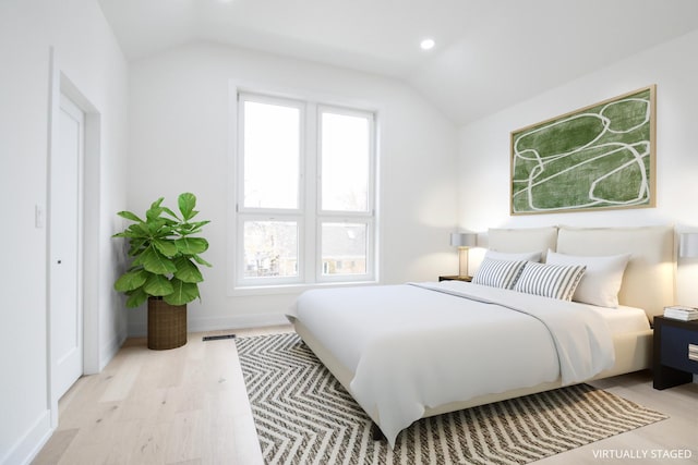 bedroom featuring lofted ceiling and light wood-type flooring