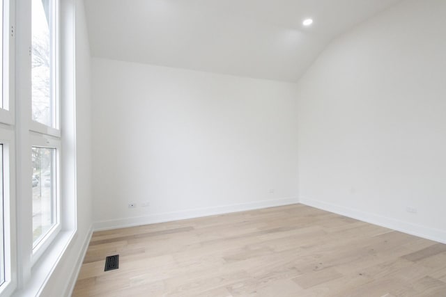 empty room featuring light hardwood / wood-style floors and vaulted ceiling