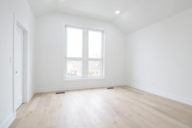 bonus room with vaulted ceiling and light wood-type flooring