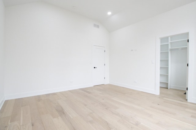 unfurnished bedroom with lofted ceiling and light wood-type flooring