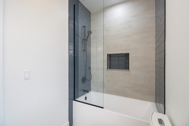 bathroom with tiled shower / bath combo and toilet