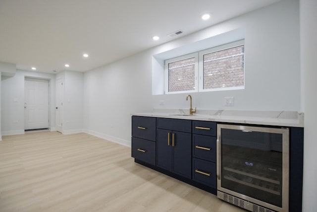 bar featuring wine cooler, sink, and light wood-type flooring