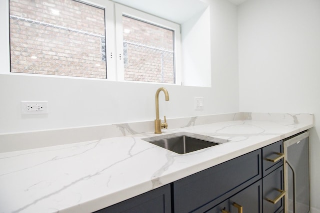 kitchen featuring light stone countertops and sink