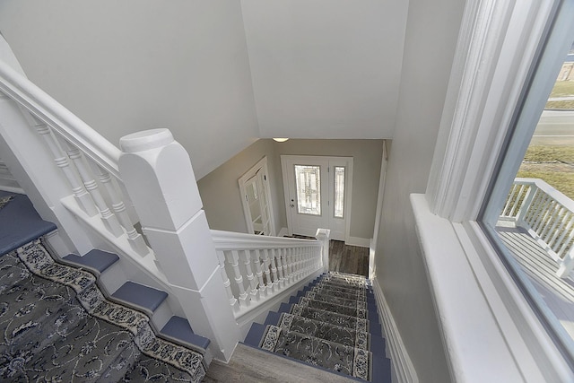 staircase featuring hardwood / wood-style floors and vaulted ceiling