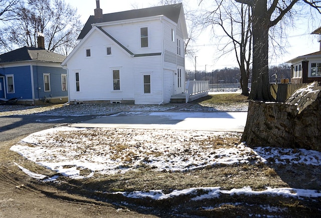 view of snow covered back of property