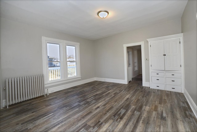 unfurnished bedroom featuring radiator and dark wood-type flooring